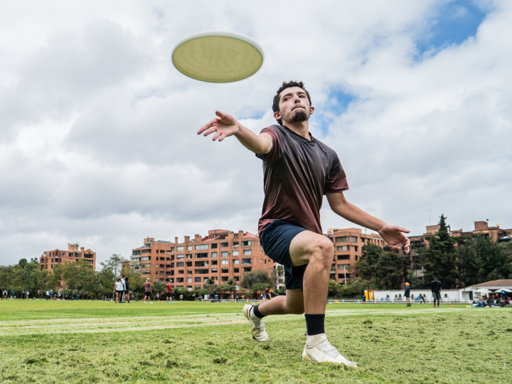 student throwing a frisbee on campus