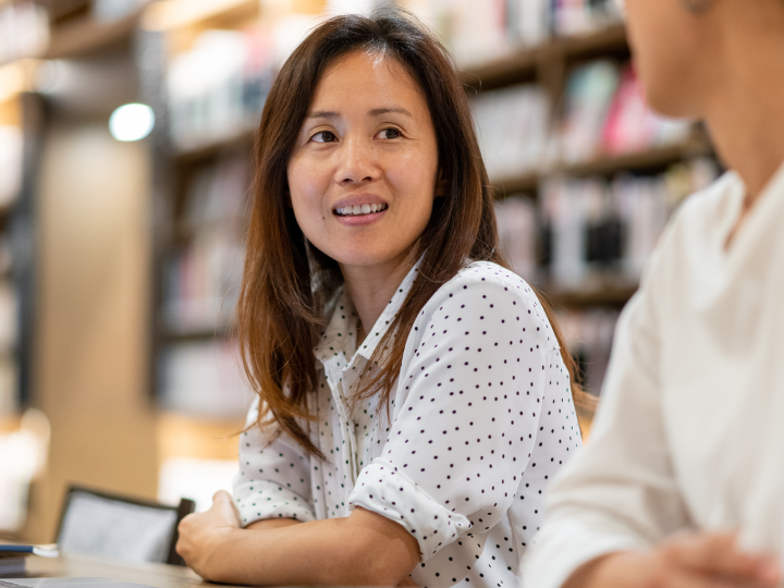 woman sitting at a table in a library 